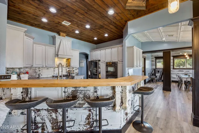 a kitchen with stainless steel appliances granite countertop a sink a stove and a refrigerator