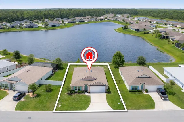 an aerial view of a house with a garden and houses