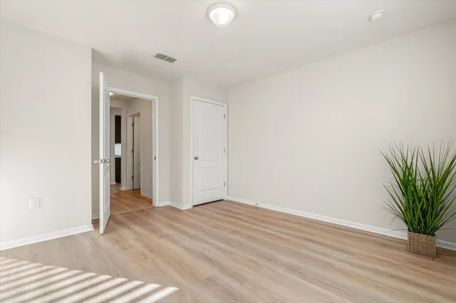 a view of a room with wooden floor and a potted plant