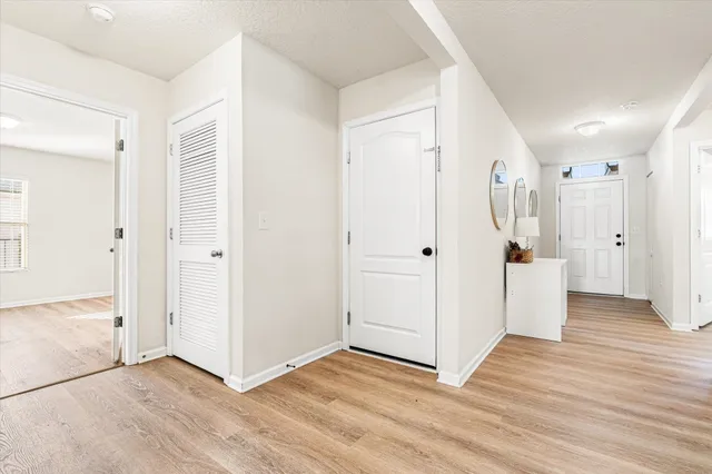 a view of a hallway with wooden floor and entryway