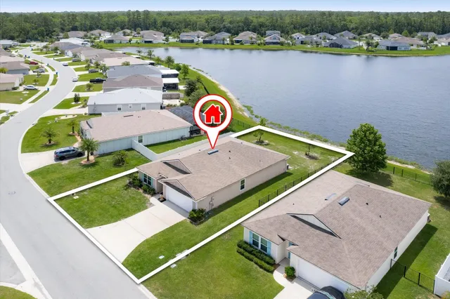 an aerial view of residential houses with outdoor space and parking