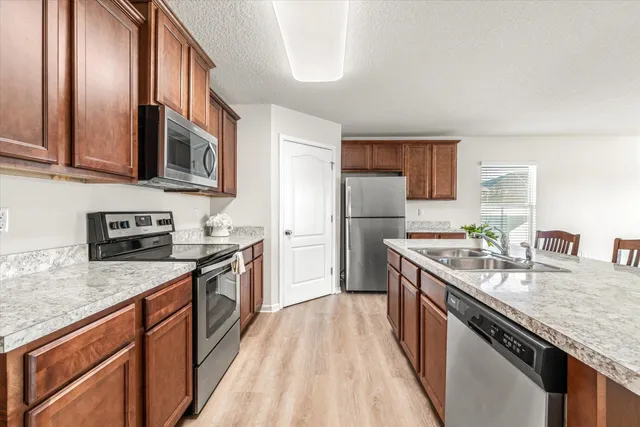 a kitchen with stainless steel appliances granite countertop a stove a sink dishwasher and a refrigerator