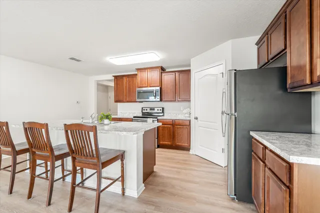 a kitchen with a table chairs refrigerator and microwave