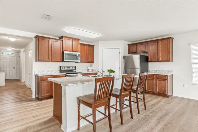 a kitchen with a dining table chairs refrigerator and cabinets