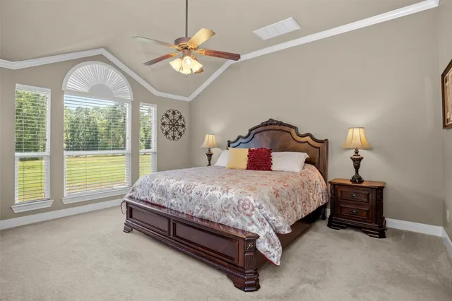 a bedroom with a bed dresser and a large window