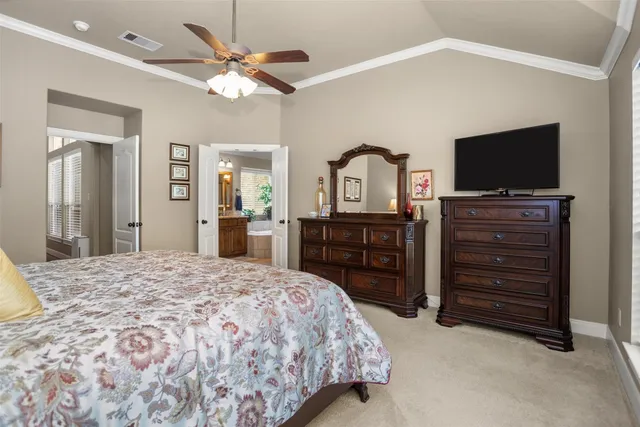 a spacious bedroom with a bed and a flat screen tv