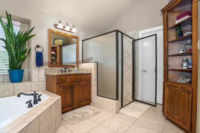 a spacious bathroom with a double vanity sink a mirror and a bathtub