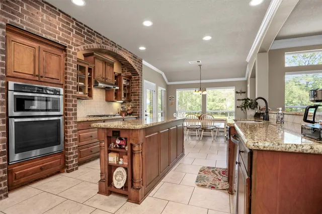 a kitchen with stainless steel appliances granite countertop a sink stove and cabinets