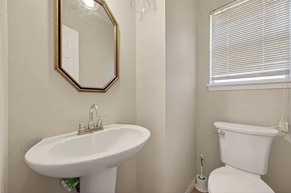 a bathroom with a toilet a sink and a mirror