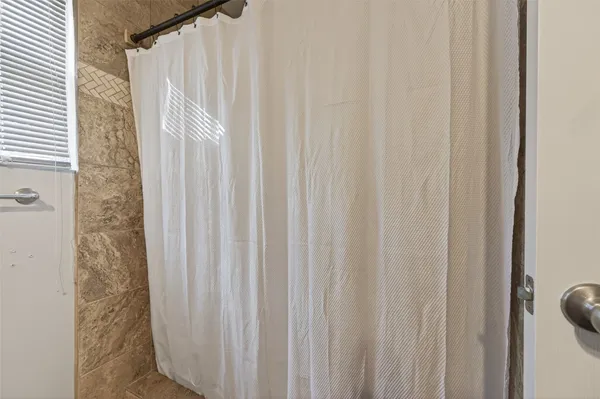 a view of a bathroom with shower curtain
