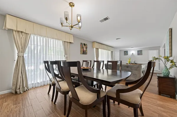 a view of a a dining room with furniture window and wooden floor