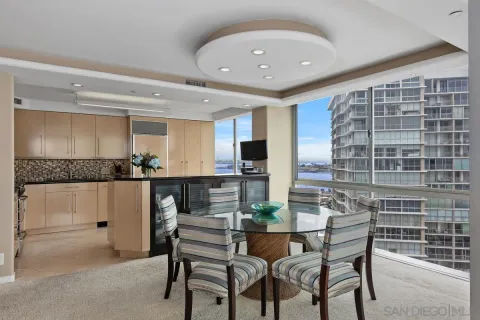 a kitchen with a dining table chairs and large window