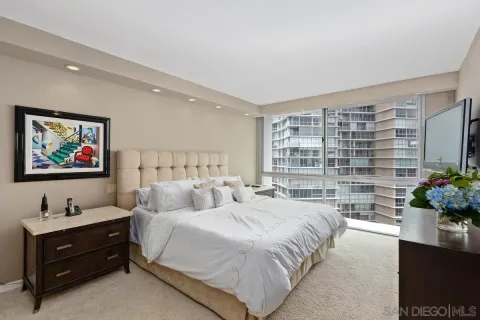 a spacious bedroom with a large bed and a flat screen tv