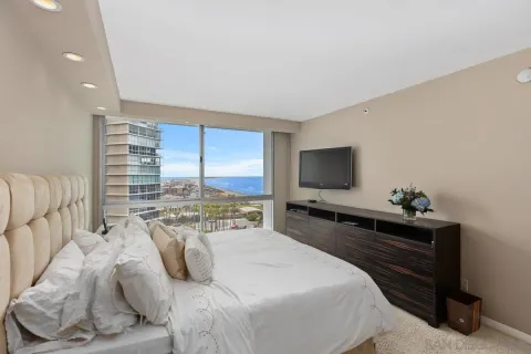 a bedroom with a bed and large windows