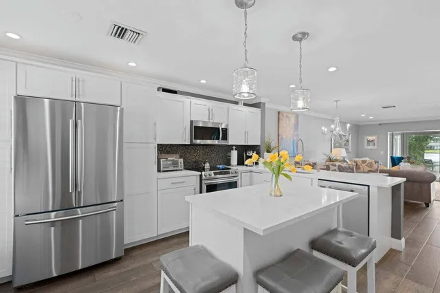 a kitchen with refrigerator and chairs