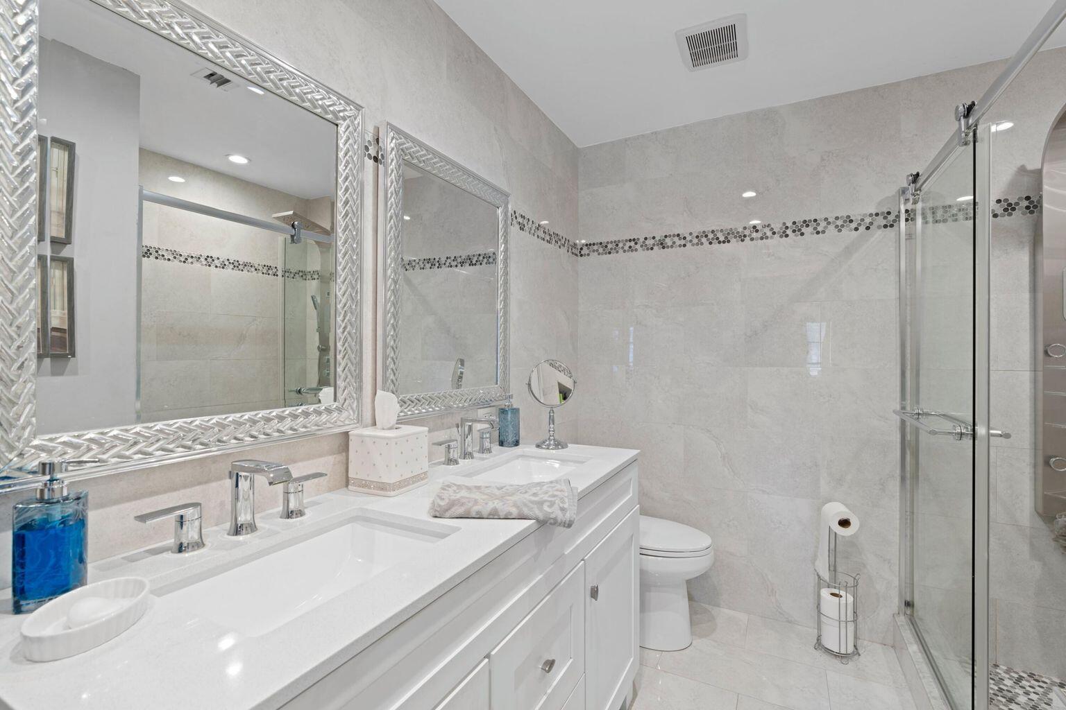 5400 Poppy Place, Unit B Delray Beach, FL 33484 - Photo 12 of 23 a bathroom with a double vanity sink toilet mirror and shower