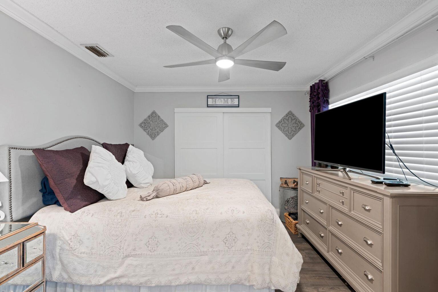 5400 Poppy Place, Unit B Delray Beach, FL 33484 - Photo 14 of 23 a bedroom with a bed and a flat screen tv