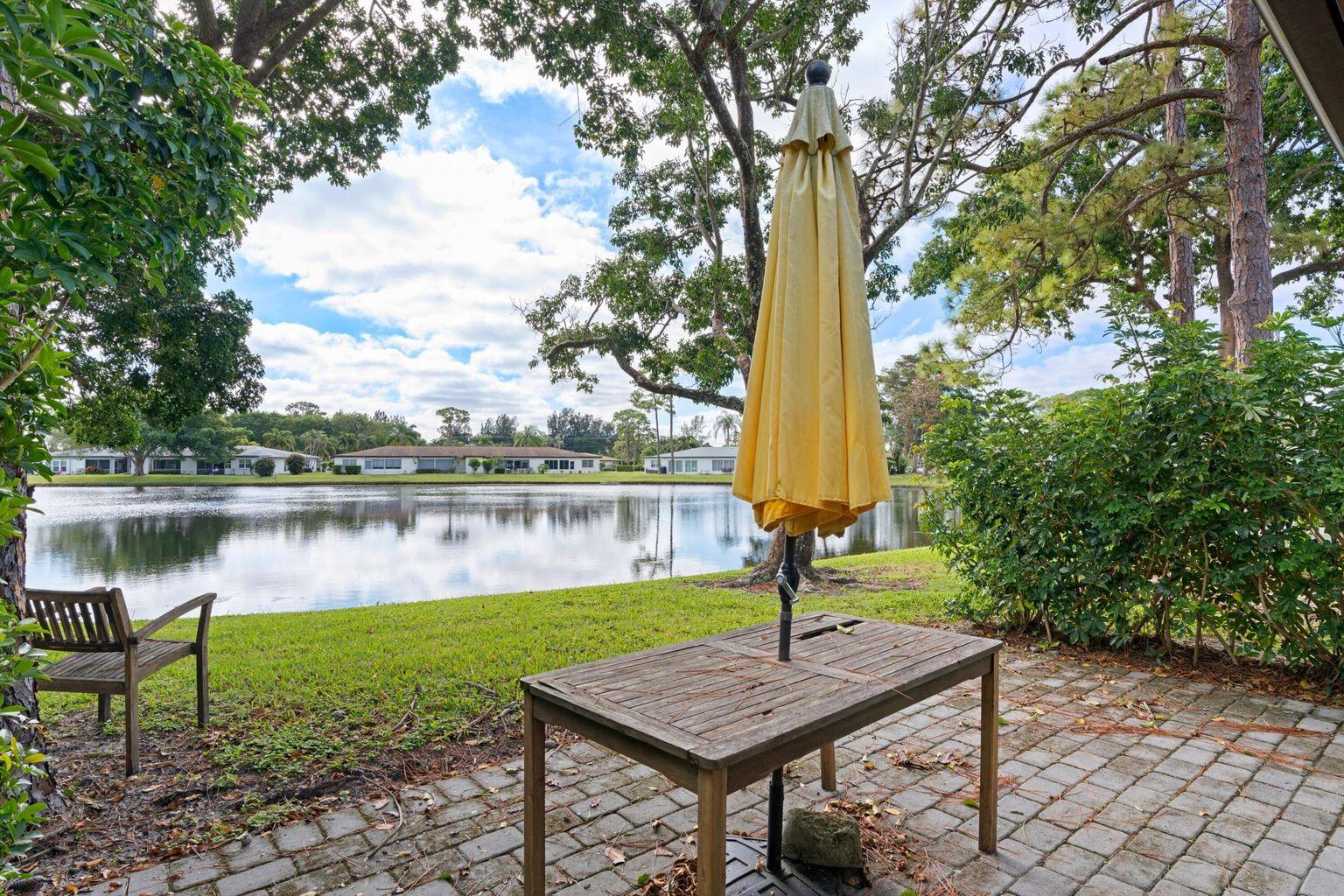 5400 Poppy Place, Unit B Delray Beach, FL 33484 - Photo 19 of 23 a view of a lake with a table and chairs