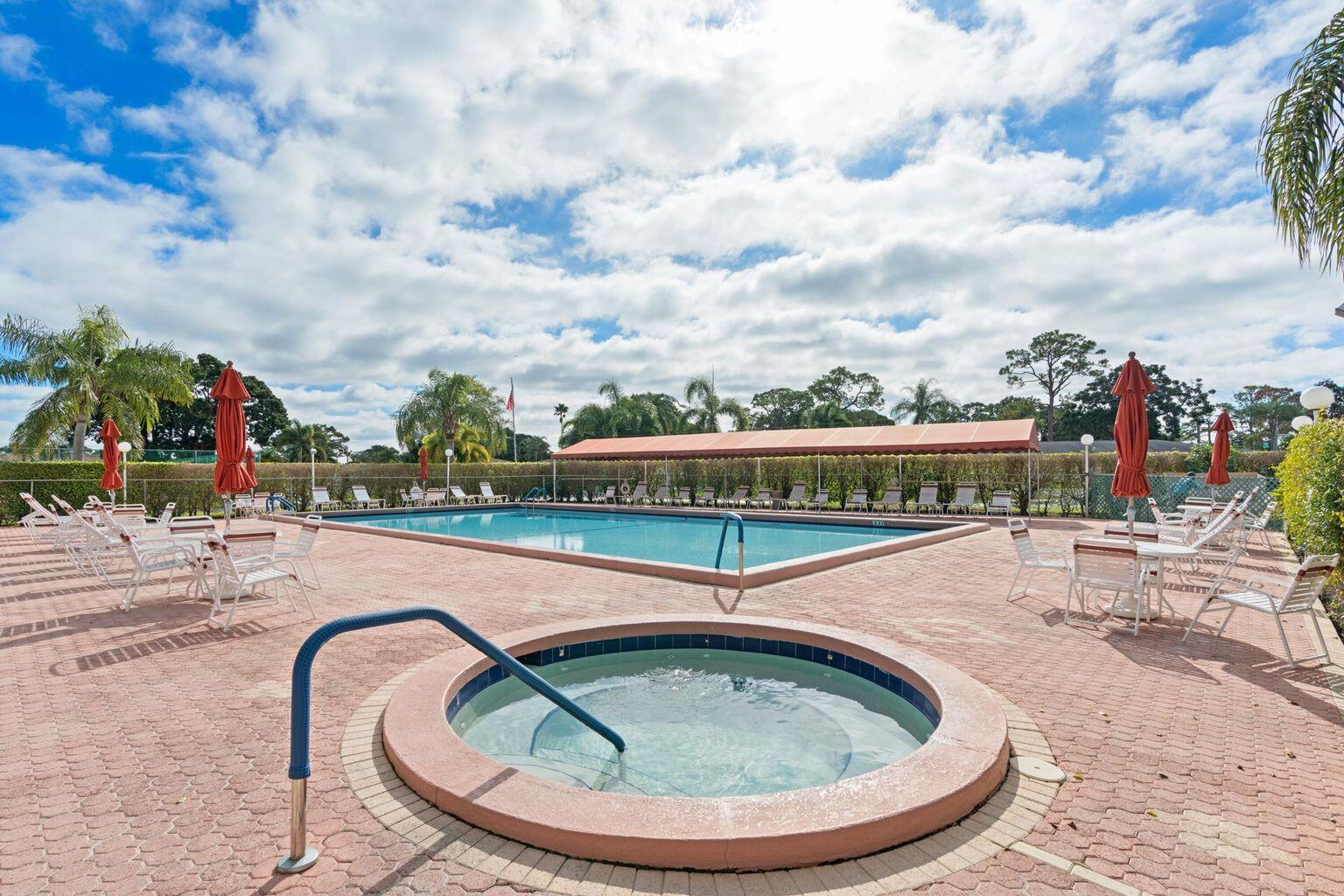 5400 Poppy Place, Unit B Delray Beach, FL 33484 - Photo 23 of 23 a view of a swimming pool with a lounge chair