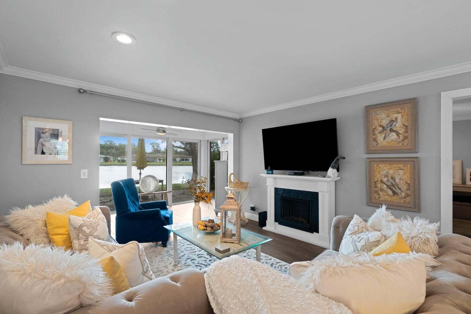 5400 Poppy Place, Unit B Delray Beach, FL 33484 - Photo 8 of 23 a living room with furniture a flat screen tv and a fireplace