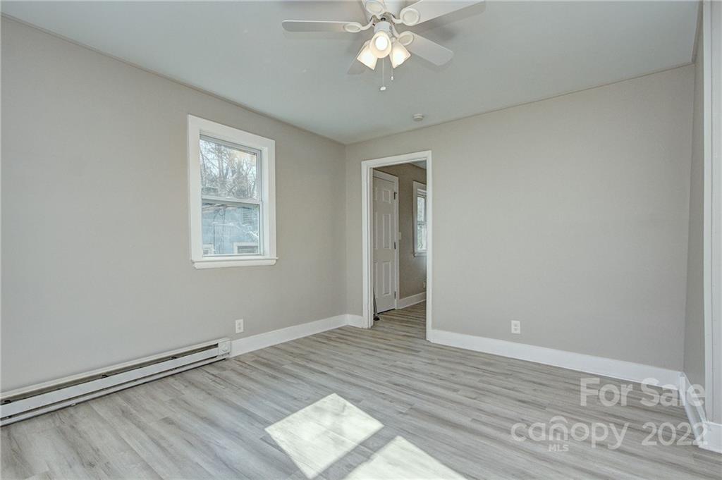 3128-3130 Ridge Avenue Charlotte, NC 28208 - Photo 13 of 22 a view of an empty room with wooden floor and a window