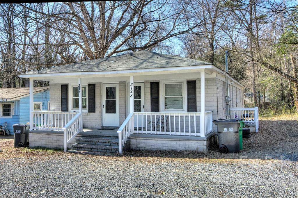 3128-3130 Ridge Avenue Charlotte, NC 28208 - Photo 3 of 22 a view of a house with a bench in a backyard