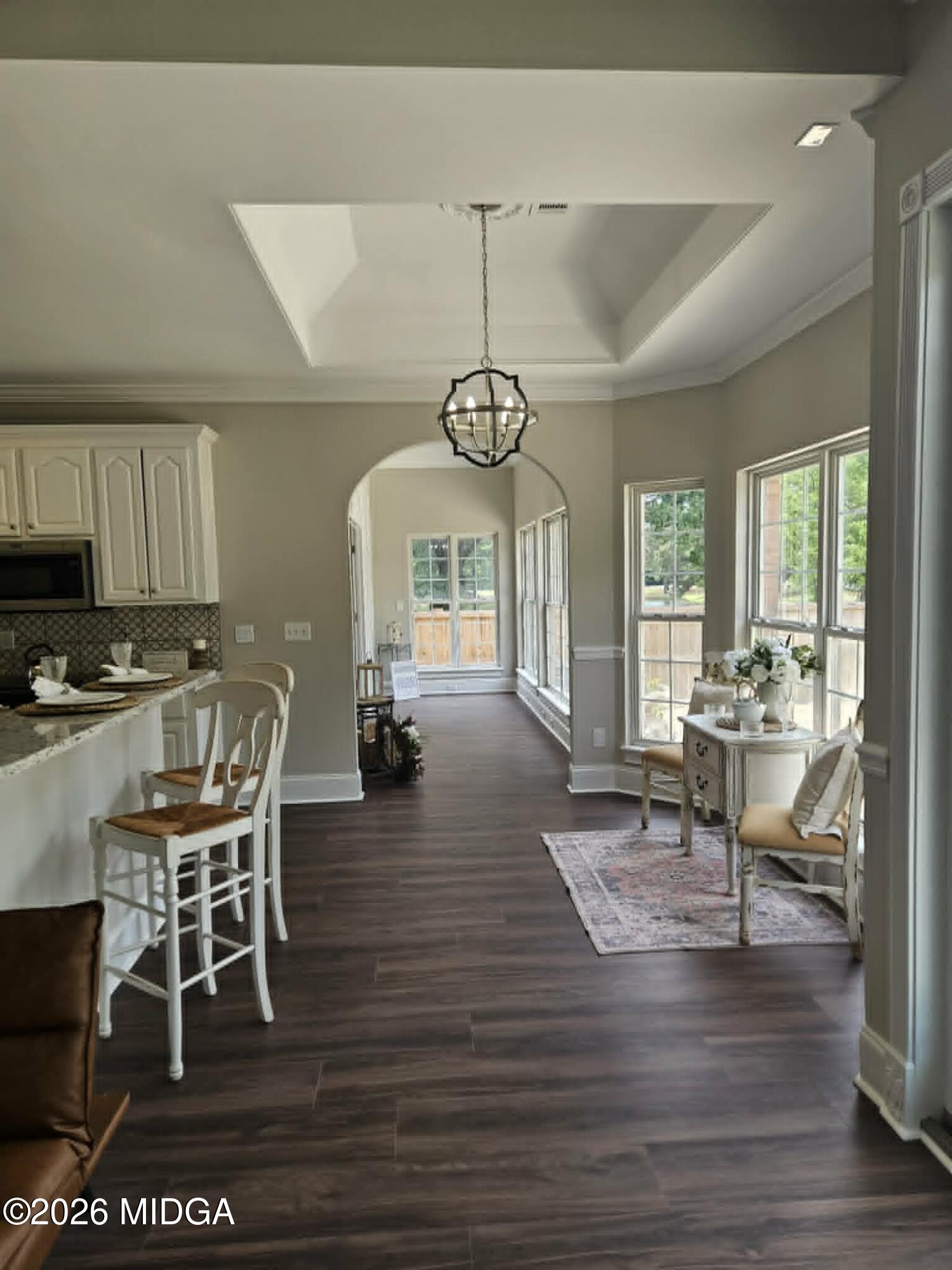 214 Tivoli Park Road Centerville, GA 31028 - Photo 8 of 26 a dining room with wooden floor a chandelier a glass table and chairs
