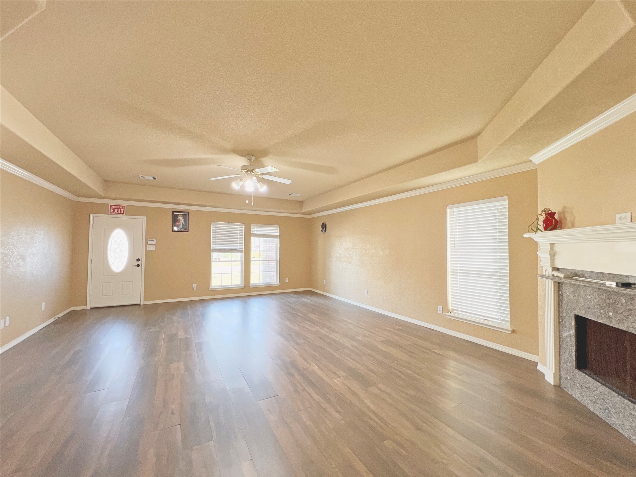 10018 San Ignacio Houston, TX 77075 - Photo 5 of 14 an empty room with wooden floor fireplace and windows