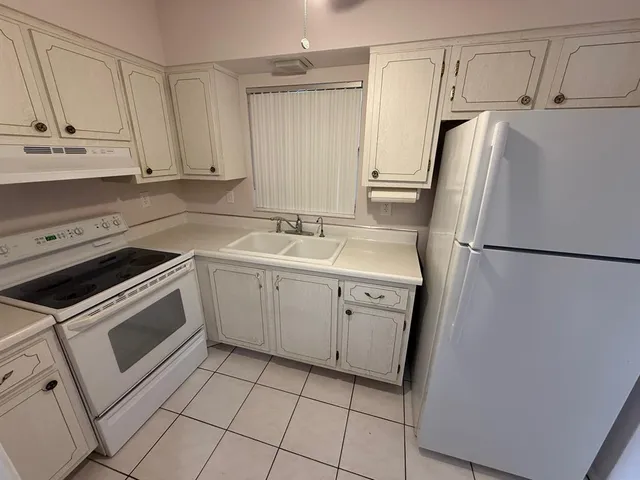 a kitchen with a refrigerator sink and cabinets