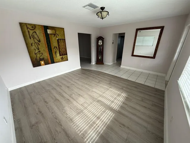 a view of a hallway with wooden floor and windows