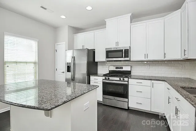 a kitchen with granite countertop a sink and a window