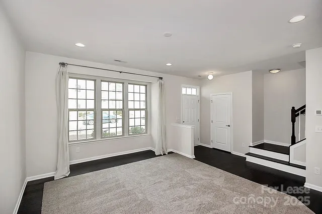 a view of a kitchen with a sink and dishwasher a refrigerator with white cabinets