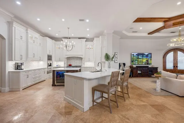 a large kitchen with kitchen island a sink a stove a dining table and chairs