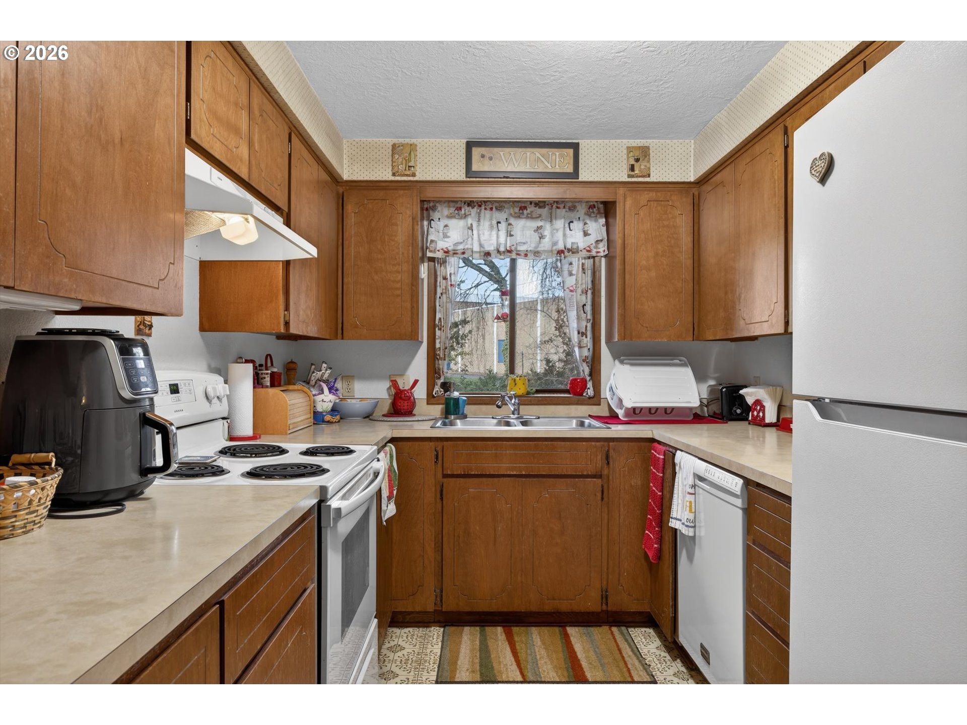 8050 Southwest 103rd Avenue Beaverton, OR 97008 - Photo 42 of 48 a kitchen with a sink a stove a refrigerator and cabinets