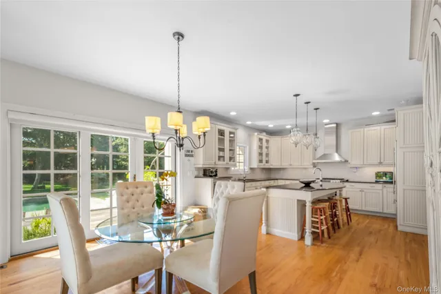 a view of a dining room and livingroom with furniture wooden floor a chandelier