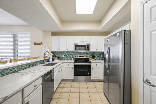 a kitchen with stainless steel appliances granite countertop a refrigerator and a sink