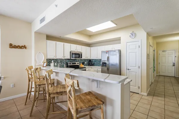 a kitchen with stainless steel appliances kitchen island granite countertop a refrigerator and cabinets