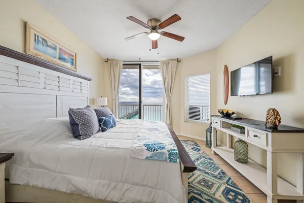 a bedroom with a bed and a large window