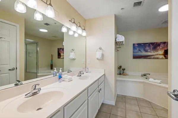 a bathroom with a double vanity sink mirror and bathtub