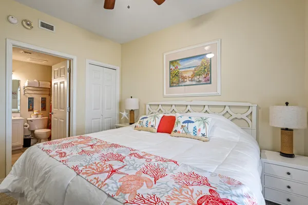 a bedroom with a bed and a lamp on dresser