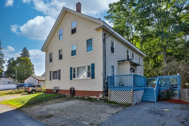 a front view of a house with a yard and outdoor seating