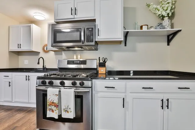 a kitchen with stainless steel appliances a stove and a microwave