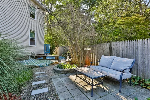 a backyard of a house with barbeque oven table and chairs