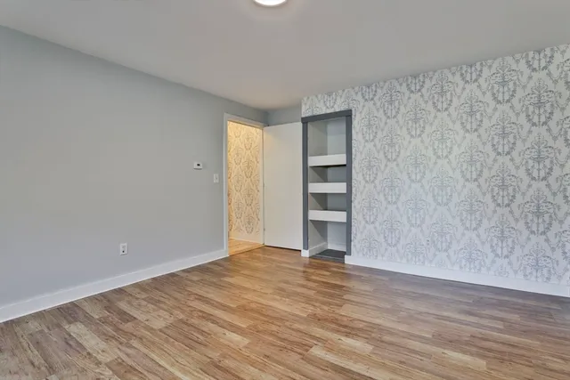 a view of empty room with wooden floor
