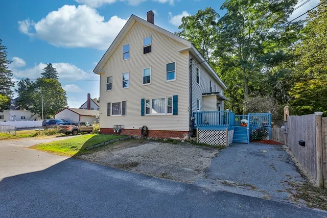 a view of a house with backyard and a tree