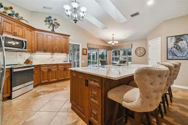 a large kitchen with granite countertop a sink and a large window