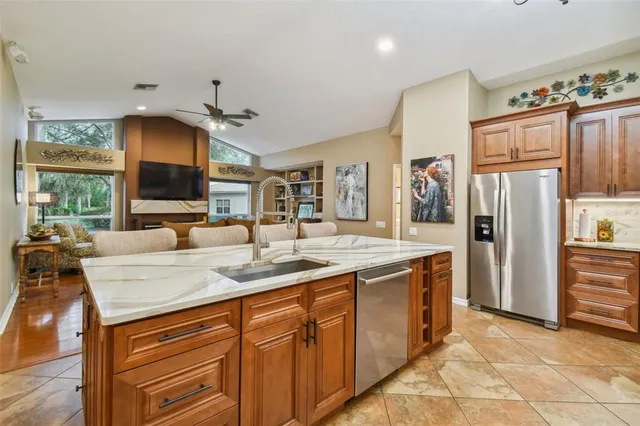 a kitchen with stainless steel appliances granite countertop a sink refrigerator and cabinets