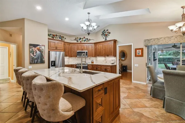 a living room with stainless steel appliances kitchen island granite countertop a sink and cabinets
