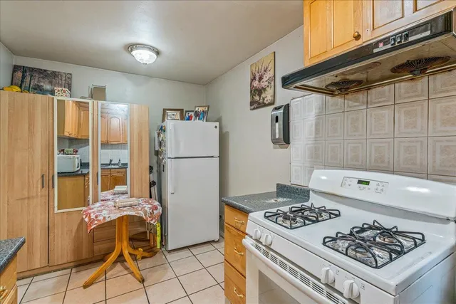 a kitchen with a refrigerator and a stove top oven