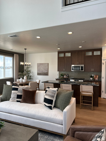 2011 West 1150 South, Unit 1042 Payson, UT 84651 - Photo 23 of 39 Photos are of model home.Open-concept living area featuring high ceilings, wood-finish flooring, a kitchen island with seating, dark wood cabinetry, and stainless steel appliances